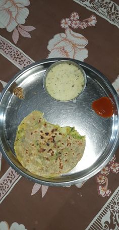 a plate with some food on it and sauces in the bowl next to it