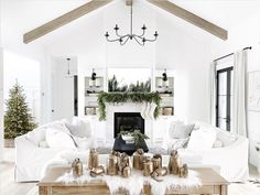 a living room filled with furniture and a fire place in front of a christmas tree