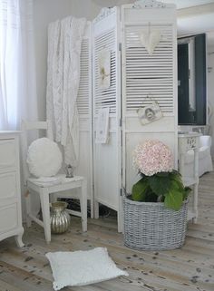 a bedroom with white furniture and flowers on the floor