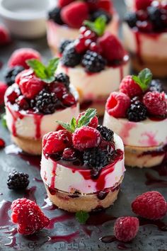 mini cheesecakes with berries and raspberries are on the table ready to be eaten