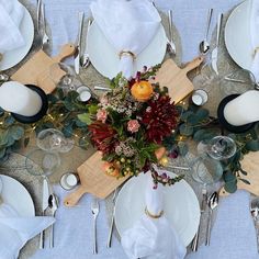 an overhead view of a table set with white plates, silverware and floral centerpieces