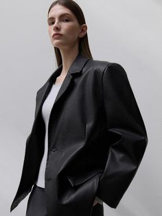 This product is a Section Faux Leather Jacket that offers a sleek and contemporary look with its clean design and sharp tailoring. The jacket provides a luxurious feel and appearance, while being a conscious choice with its faux leather material. It is structured to deliver a smart fit that complements both casual and formal outfits. - The jacket features a refined faux leather finish, presenting a polished and versatile outerwear option.- Its precise cut and tailored design ensure a flattering fit that enhances the silhouette.- The jacket includes subtle detailing that adds depth to the simple yet sophisticated style.- Built for both style and practicality, the interior is lined for additional comfort and warmth. Modern Black Outerwear With Pressed Crease, Tailored Modern Leather Jacket For Fall, Modern Leather Jacket For Business Casual, Modern Leather Jacket For Formal Fall Wear, Modern Leather Jacket For Fall Formal Events, Modern Formal Leather Jacket For Fall, Classic Faux Leather Single-breasted Jacket, Elegant Single Breasted Faux Leather Blazer, Tailored Leather Outerwear In Modern Style