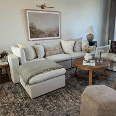 a living room filled with furniture and a painting on the wall above it's headboard