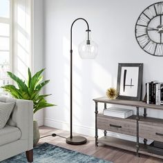 a living room with a couch, table and large clock on the wall above it