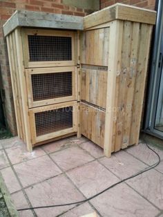 a large wooden box sitting on the side of a brick wall next to a door