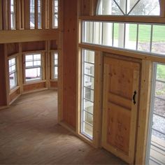 an empty room with wooden walls and windows