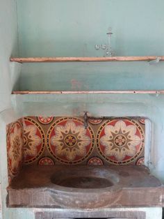 an old wooden bench sitting in the corner of a room with blue walls and flooring