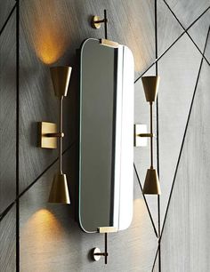 a wall mounted mirror with three lights on it and a light fixture in the middle