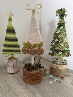 three small christmas trees sitting on top of a wooden table