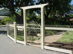 a white gate with an iron fence around it