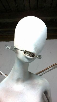 a white mannequin with metal wire attached to it's head