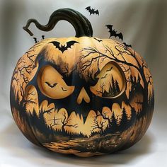 a carved pumpkin with bats and trees on it