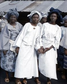 an old photo of women in white dresses and turbans posing for the camera