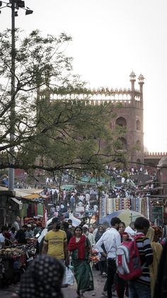 many people are walking around an outdoor market