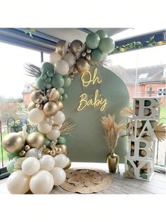 a baby shower is decorated with balloons and greenery