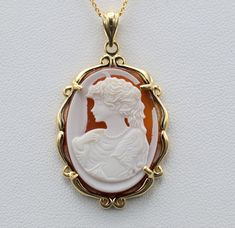 Vintage Yellow Gold Pendant set with Carved Cameo. Crafted in desirable yellow gold, this ladies pendant measures 1.25 inches in height without the bail. In excellent condition, this pendant would look great added to an existing chain of yours or with one from our shop. Chains are available for purchase in any size. Each piece has been hand selected and meticulously identified and graded by a Graduate Gemologist who has been awarded a degree by the Gemological Institute of America (GIA). Please Cabochon Necklace For Anniversary, Yellow Gold Oval Necklace With Intaglio, Gold Intaglio Necklace, Round Intaglio Jewelry, Yellow Gold Cameo Round Pendant Necklace, Yellow Gold Cameo Necklace With Round Pendant, Yellow Gold Intaglio Jewelry, Gold Oval Pendant With Cameo Detail, Yellow Gold Cameo Pendant Necklace