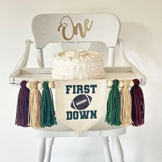 a first down cake sitting on top of a chair with tassels around it