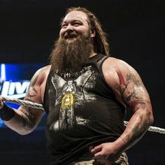 a man with long hair and beard holding a rope in his hand while wearing a black shirt