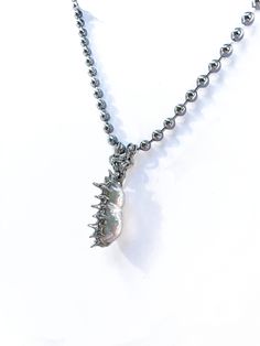 An off white iridescent oblong pearl soldered with soft metal on a 16 in. steel ball chain.  Due to the natural state of the pearl and its handmade nature, the color, shape, and silver solder spheres may vary. Silver Metal Pearl Necklace With Beaded Chain, Silver Ball Chain Necklace In Stainless Steel, Silver Ball Chain Necklace As A Gift, Silver Necklace With Ball Chain As Gift, Silver Necklace With Ball Chain For Gift, Silver Dog Tag Ball Chain Necklace, Silver Dog Tag Necklace With Ball Chain, Silver Jewelry With Ball Chain For Gift, Silver Minimalist Pearl Necklace