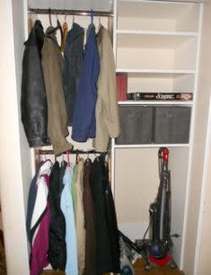 an organized closet with clothes hanging on the shelves and other items sitting on the floor