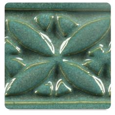 an ornate green tile with leaves on the top and bottom, is shown in this image