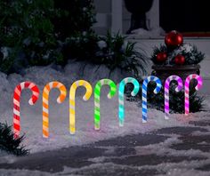 the word happy spelled out in snow with candy canes on it's sides