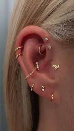 a woman's ear with three different types of piercings