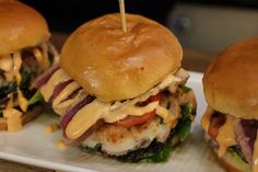 three burgers with cheese on them sitting on a plate