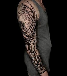 a man with a black and grey tattoo on his arm