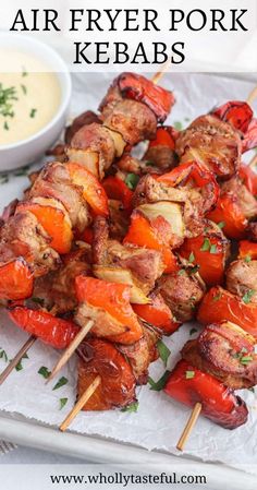 grilled meat and vegetable kabobs on skewers with dipping sauce in the background