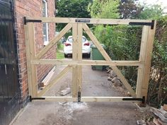 a car is parked in front of a wooden gate