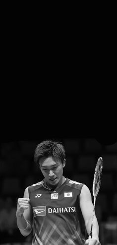 a man holding a tennis racquet in his right hand and looking down at the ground