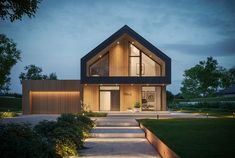 a modern house lit up at night with steps leading to the front door