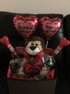 a teddy bear in a valentine's day gift box with balloons and chocolates