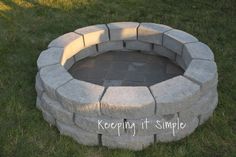 a brick fire pit sitting in the grass