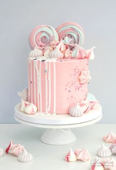 a pink cake with white icing and candies on top