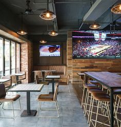 an empty restaurant with tables and chairs in front of a flat screen tv on the wall