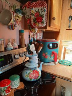 a stove top oven sitting inside of a kitchen next to pots and saucepans