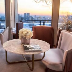 a living room filled with furniture and a chandelier hanging from the ceiling over a window