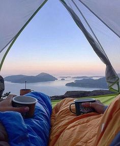 a person laying in a hammock holding a coffee cup