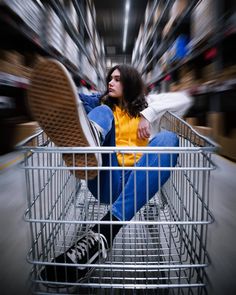 a woman sitting in a shopping cart with her feet on the floor and looking up