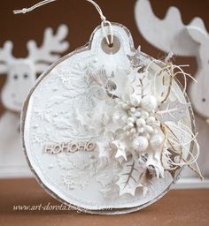 a christmas ornament with reindeers and snowflakes hanging from it's sides