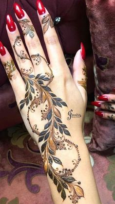 a woman's hand with henna tattoos on it