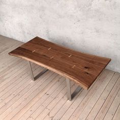 a wooden table sitting on top of a hard wood floor next to a white wall