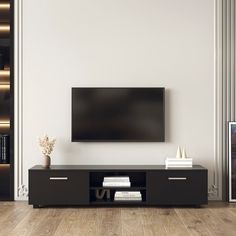 a flat screen tv sitting on top of a black entertainment center in a living room