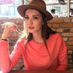 a woman sitting at a table wearing a hat