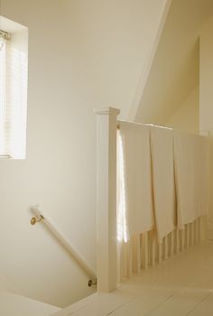 an empty bathroom with white walls and wooden floors