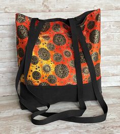 "This colorful, large tote bag will hold all of your basic essentials for a day at the beach, carry books, hold your crafts or take it to the market.  Fold flat for easy storage.  Keep it in the car for those times when you buy a few items at the store and need a sturdy, pretty bag.  Measures approx. 18\" wide, 16.5\" tall with a 4\" wide boxed bottom.  The extra long shoulder straps are approx. 24\" to the center.  Long enough for some people to wear as a crossbody bag, and comfortable for all Gift Beach Tote Bag With Adjustable Strap, Gift Beach Tote With Adjustable Strap, Adjustable Strap Tote Beach Bag Gift, Eco-friendly Orange Beach Bag For Travel, Orange Tote Beach Bag For Daily Use, Orange Tote Beach Bag For Travel, Large Capacity Orange Beach Bag For Everyday Use, Large Capacity Orange Beach Bag For Travel, Orange Shoulder Beach Bag