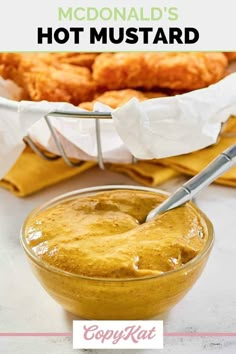 a bowl filled with mustard next to some bread