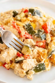 a white plate topped with an egg salad next to a fork on top of it